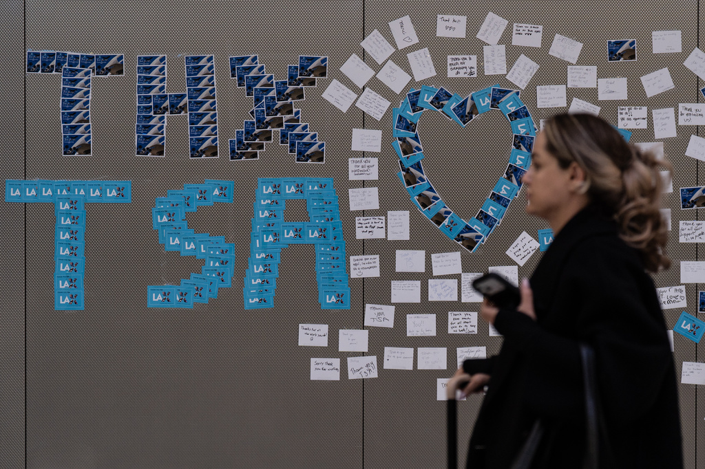 A traveler walks past a display of thank-you notes for TSA agents at Los Angeles International Airport, Friday, March 27, 2026, in Los Angeles. (AP Photo/Jae C. Hong)