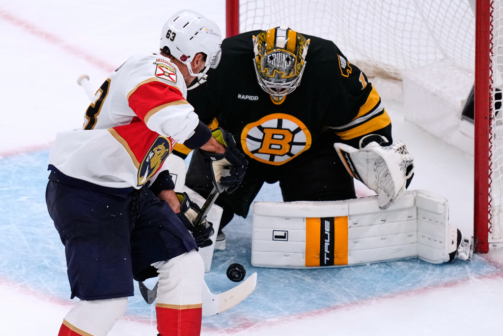 Florida Panthers left wing Brad Marchand (63) looks for the rebound as Boston Bruins goaltender Jeremy Swayman (1) drops for a save during the second period of an NHL hockey game, Tuesday, Oct. 21, 2025, in Boston. (AP Photo/Charles Krupa)