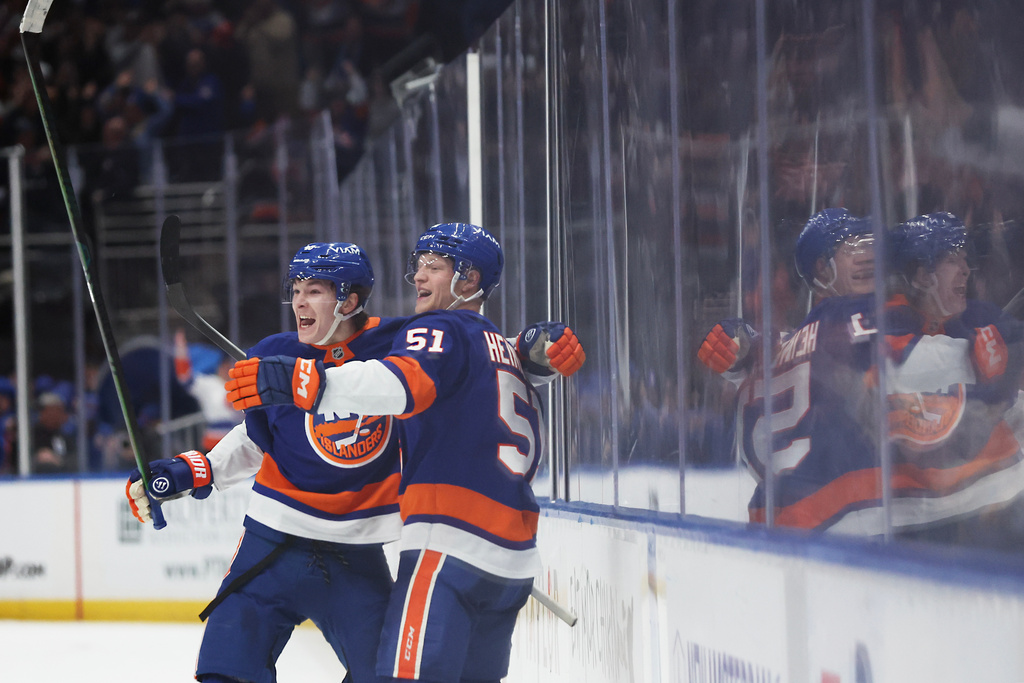 New York Islanders' Matthew Schaefer, left, and teammate Emil Heineman (51) celebrate Schaefer's goal in the overtime period of an NHL hockey game, Saturday, Jan. 3, 2026, in Elmont, N.Y. (AP Photo/Heather Khalifa)
