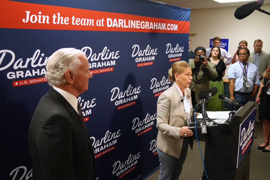 Gov. Henry McMaster, R-S.C., left, looks on as Sen. Darline Graham, R-S.C., speaks at a news conference for her campaign a day ahead of the special GOP Senate runoff to replace her brother, the late Sen. Lindsey Graham, R-S.C., Monday, Aug. 24, 2026, in Columbia, S.C. (AP Photo/Meg Kinnard)