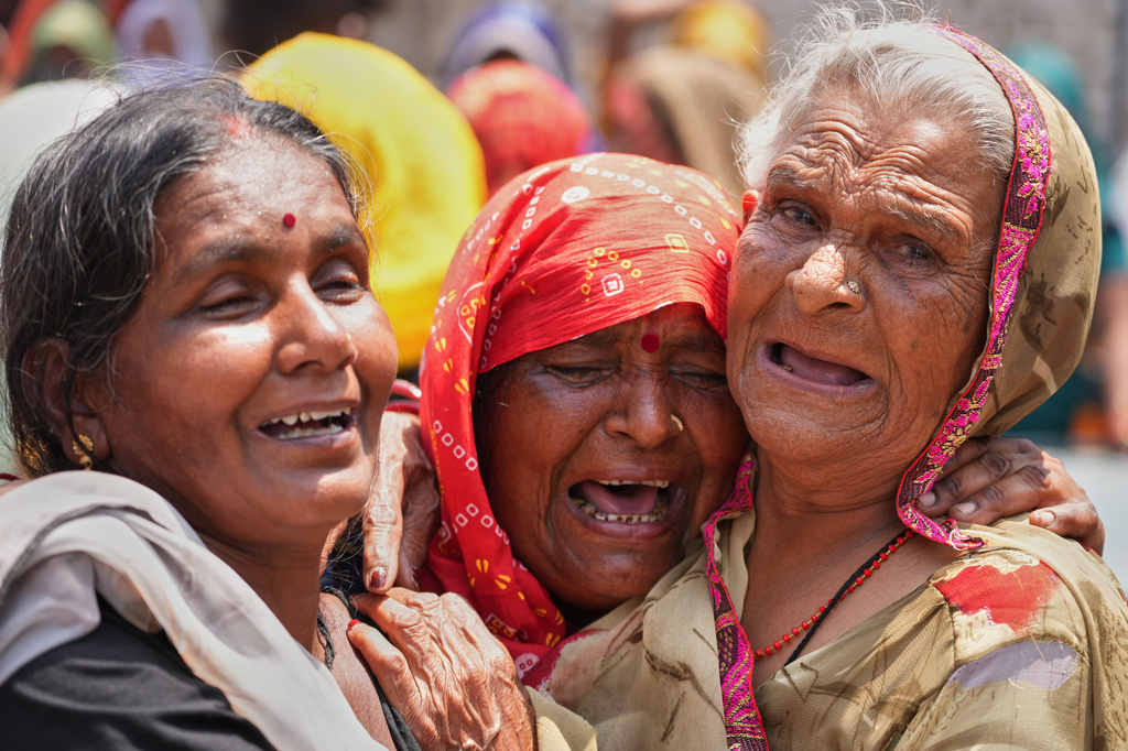 Relatives cry after seeing the body of Summit Yadav, 24, who died after a wall of his neighbor's house collapsed following dust storms and heavy rain in Prayagraj, India, Thursday, May 14, 2026. (AP Photo/Rajesh Kumar Singh)