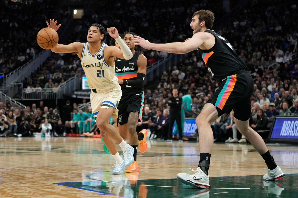 Milwaukee Bucks' Ousmane Dieng (21) controls the ball against San Antonio Spurs' Luke Kornet during the first half of an NBA basketball game Saturday, March 28, 2026, in Milwaukee. (AP Photo/Aaron Gash)