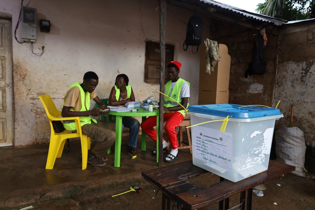 Election officials wait for voters to cast their ballots during a referendum on granting new presidential powers, in Bissau, Guinea Bissau, Sunday, Aug. 30, 2026. (AP Photo/Darcicio Barbosa)