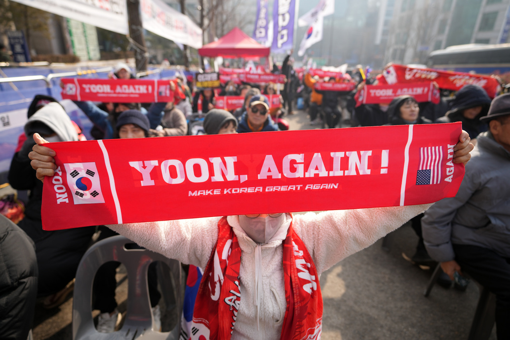 Supporters of former South Korean President Yoon Suk Yeol hold signs outside Seoul Central District Court, in Seoul, South Korea, Friday, Jan. 16, 2026. (AP Photo/Lee Jin-man)