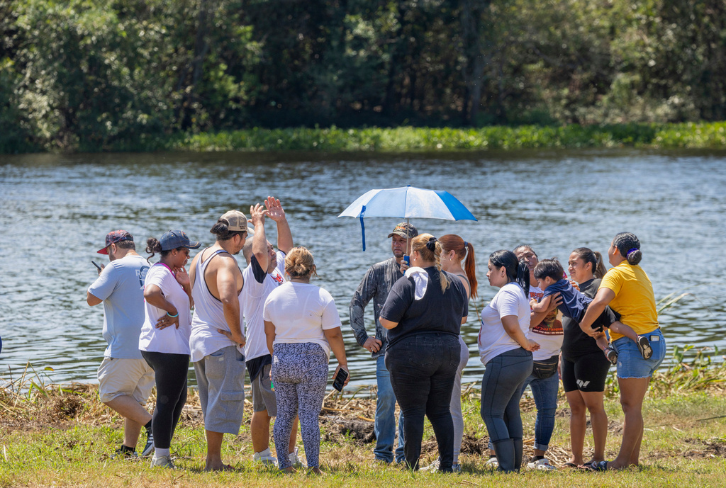 Friends, neighbors, and volunteers gather near here 12-year-old Bryan Vasquez was found dead in a canal, back center, Tuesday, Aug. 26, 2025, in New Orleans East. (Chris Granger/The Times-Picayune/The New Orleans Advocate via AP)