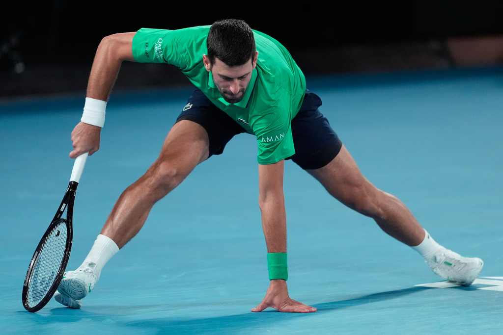 Novak Djokovic of Serbia braces himself after playing a shot to Carlos Alcaraz of Spain during the men's singles final at the Australian Open tennis championship in Melbourne, Australia, Sunday, Feb. 1, 2026. (AP Photo/Asanka Brendon Ratnayake)