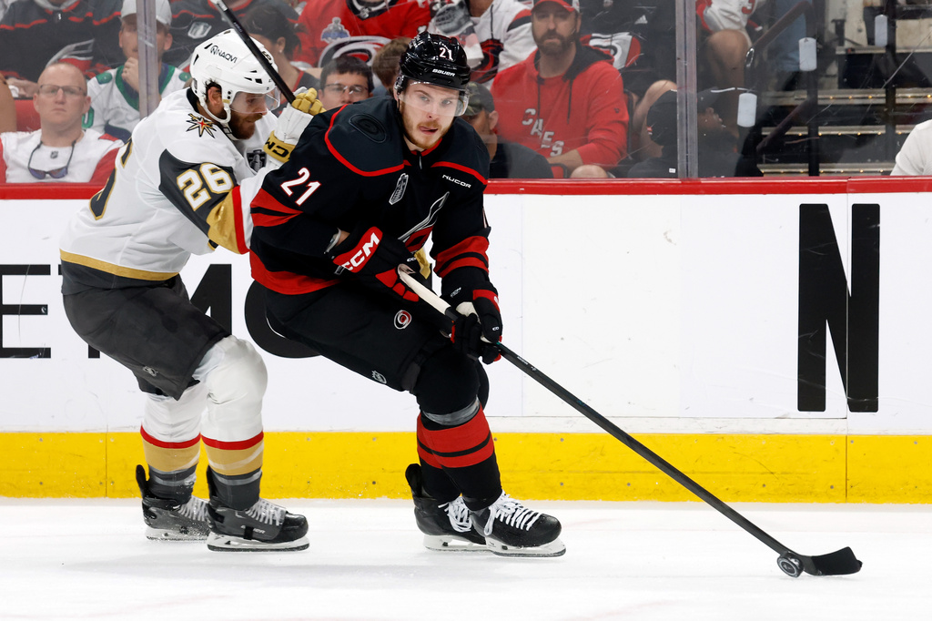 FILE - Carolina Hurricanes' Alexander Nikishin (21) protects the puck from Vegas Golden Knights' Nic Dowd (26) during the first period in Game 5 of the NHL hockey Stanley Cup Final series in Raleigh, N.C., June 11, 2026. (AP Photo/Karl DeBlaker, File)