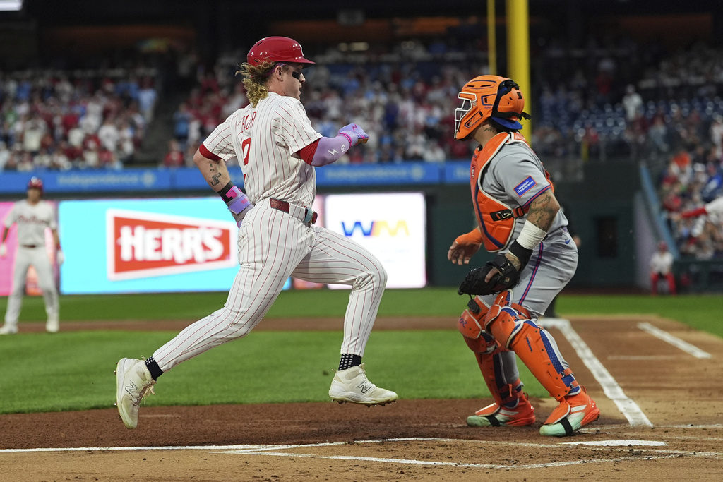 Philadelphia Phillies' Max Kepler scores past New York Mets catcher Francisco Alvarez off of a single hit by J.T. Realmuto during the first inning of a baseball game, Wednesday, Sept. 10, 2025, in Philadelphia. (AP Photo/Matt Rourke)