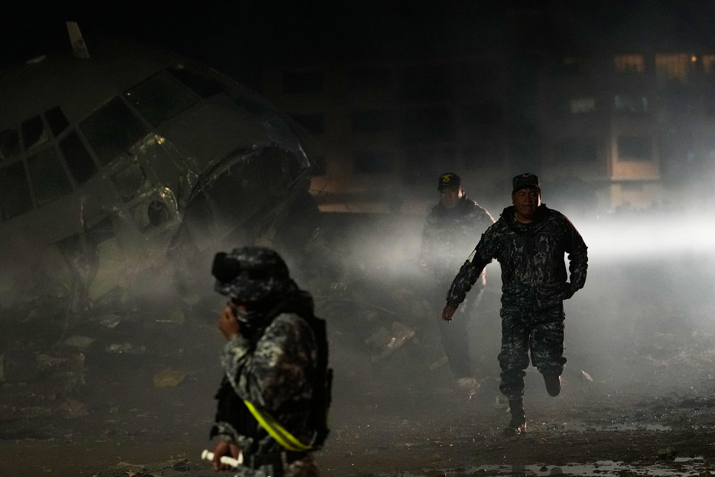 Military police on the scene where a plane crashed in El Alto, Bolivia, Friday, Feb. 27, 2026. (AP Photo/Juan Karita)