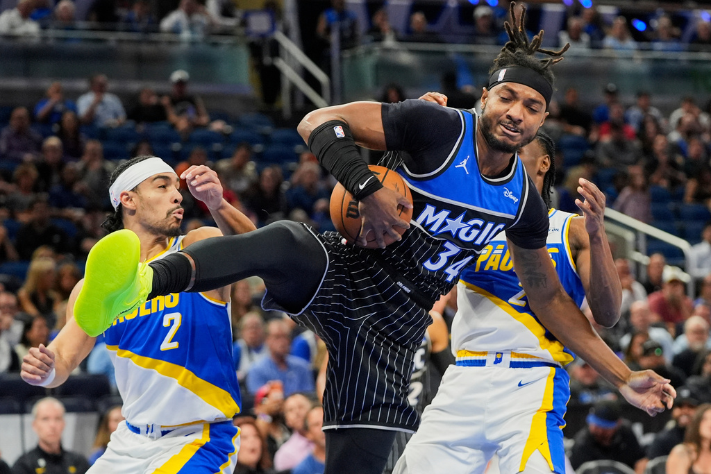 Orlando Magic center Wendell Carter Jr. (34) grabs a rebound in front of Indiana Pacers guard Andrew Nembhard (2) and guard Aaron Nesmith during the first half of an NBA basketball game, Monday, March 23, 2026, in Orlando, Fla. (AP Photo/John Raoux)
