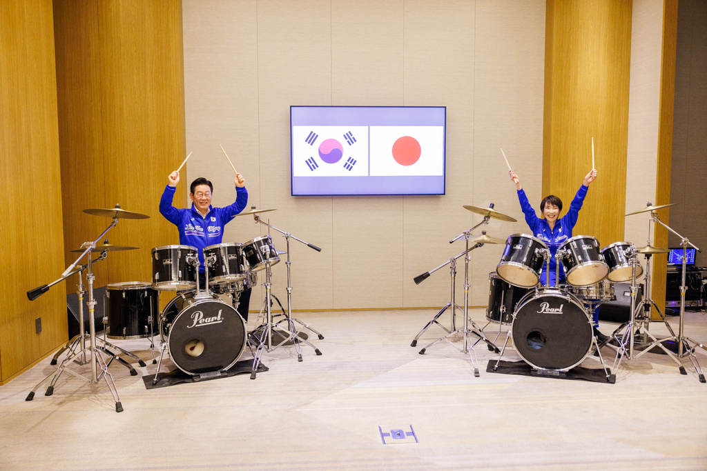 In this photo released on the official website of Prime Minister's Office of Japan, Japanese Prime Minister Sanae Takaichi, right, and South Korean President Lee Jae Myung play drump together after their talks in Nara, western Japan Tuesday, Jan. 13, 2026. (Prime Minister's Office of Japan via AP)