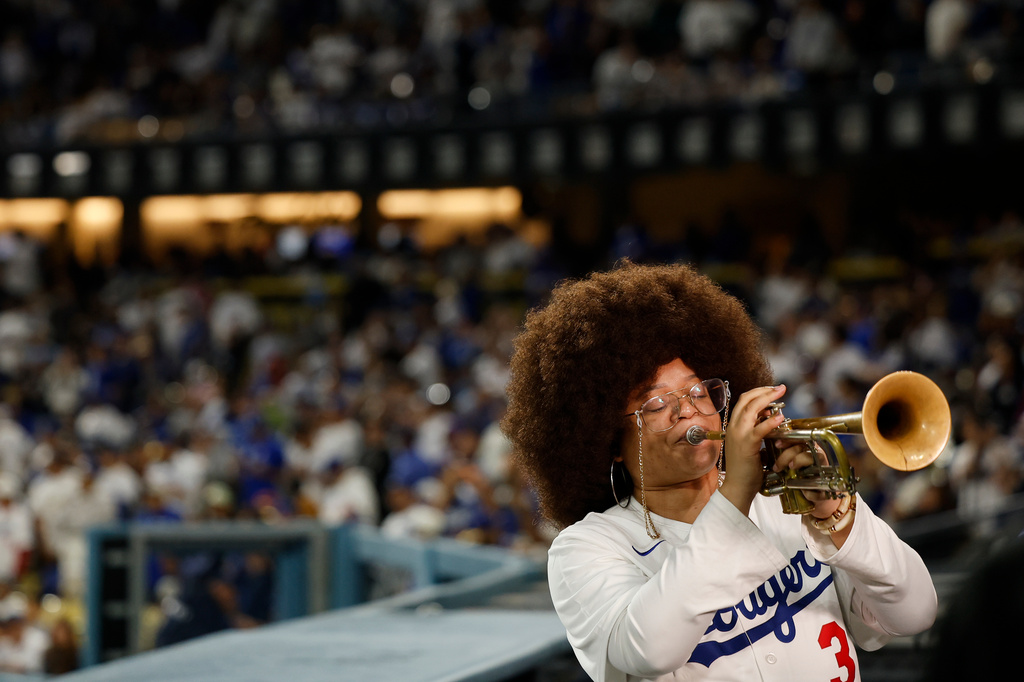 Tatiana Tate plays the trumpet as Los Angeles Dodgers relief pitcher Edwin Diaz runs out to field in between the eighth and ninth innings of a baseball game Friday, March 27, 2026, in Los Angeles. (AP Photo/Caroline Brehman)