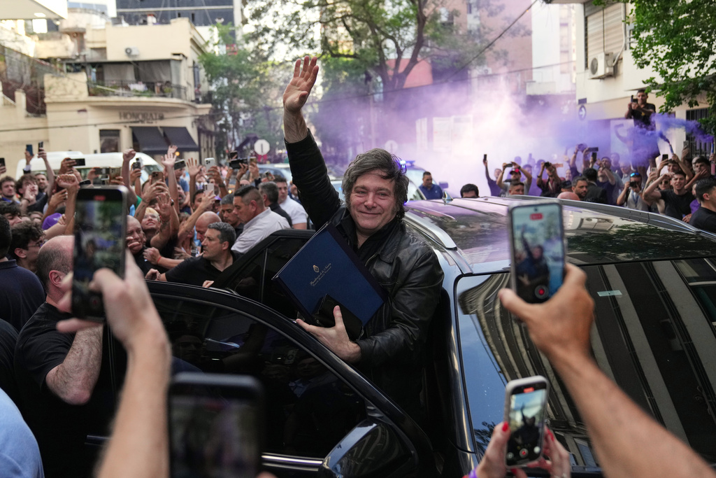 Argentine President Javier Milei waves to supporters upon arriving at a hotel in Rosario, Argentina, Thursday, Oct. 23, 2025. (AP Photo/Rodrigo Abd)