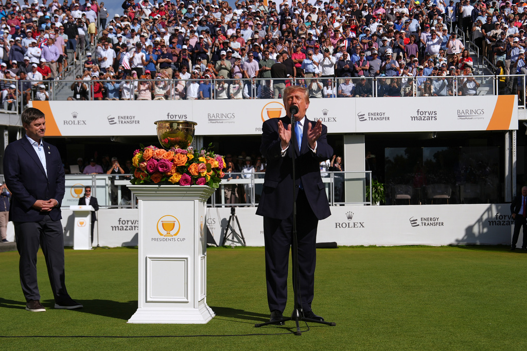President Donald Trump speaks as PGA Tour CEO Brian Rolapp listens at the Presidents Cup golf tournament at Medinah Country Club, Sunday, Sept. 27, 2026, in Medinah, Ill. (AP Photo/Julia Demaree Nikhinson)