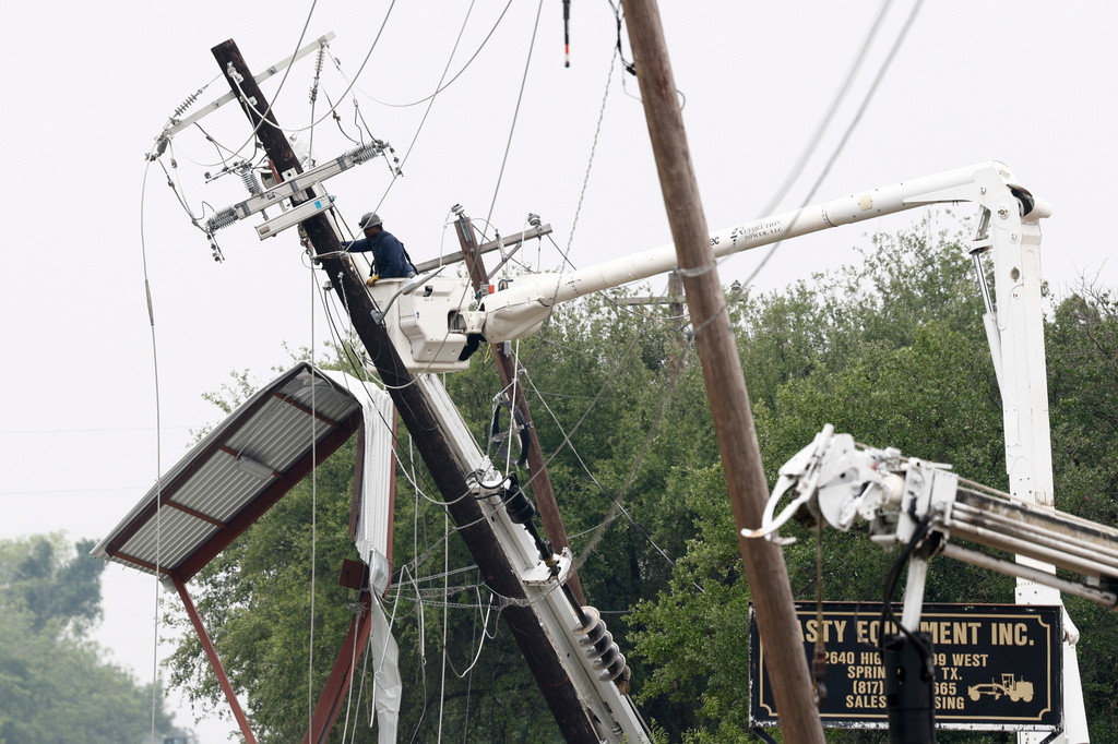 A lineman works to repair a damaged power pole after severe weather hit the area, Sunday, April 26, 2026, in Springtown, Texas. (Elías Valverde II/The Dallas Morning News via AP)