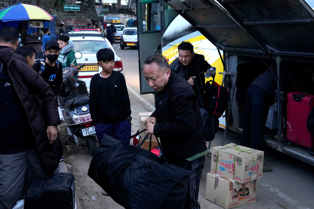 Sonam Tashi, right, and his son, Kunga Tenzin, take their luggage from a bus after reaching Dharamshala, India, where Tashi hopes the Tibetan government in exile can help his son access education, March 5, 2025. (AP Photo/Manish Swarup)