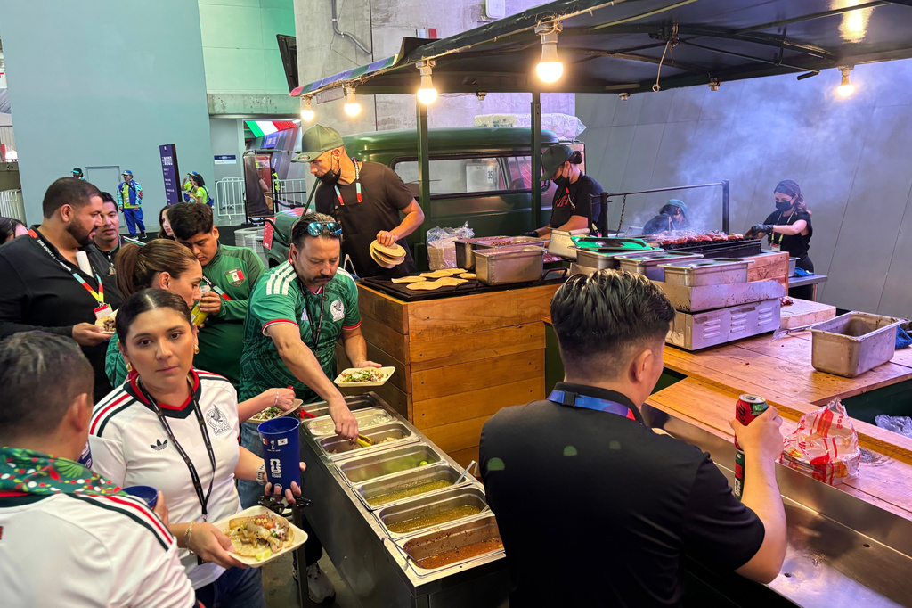 Fans attending the World Cup soccer game between Mexico and South Korea in Zapopan, near Guadalajara, Mexico, Thursday, June 18, 2026, buy food at a concession stand inside Guadalajara Stadium. (AP Photo/Tales Azzoni)