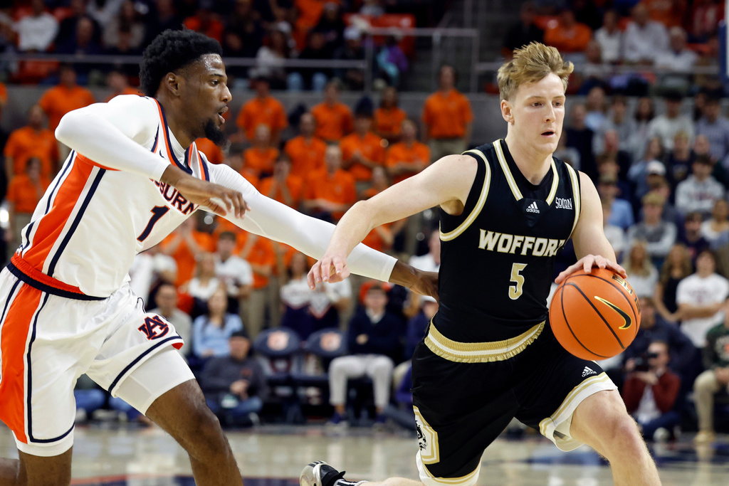 Wofford guard Brendan Rigsbee (5) dribbles around Auburn guard Kevin Overton (1) during the first half of an NCAA college basketball game, Tuesday, Nov. 11, 2025, in Auburn, Ala. (AP Photo/Butch Dill)