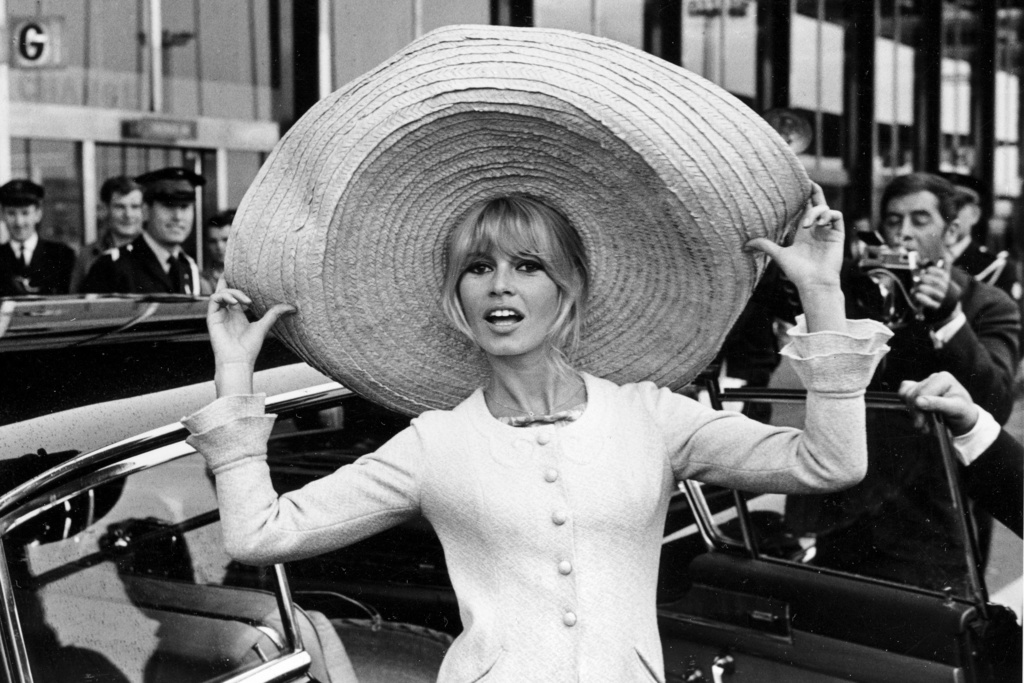 FILE - French actress Brigitte Bardot poses with a huge sombrero she brought back from Mexico, as she arrives at Orly Airport in Paris, France, on May 27, 1965. (AP Photo/File)