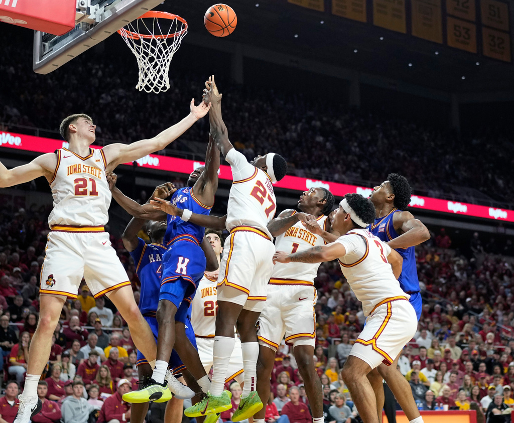 Iowa State forward Dominykas Pleta (21) and guard Killyan Toure (27) battle for a rebound with Kansas guard Melvin Council Jr. (14) during the first half of an NCAA college basketball game, Saturday, Feb. 14, 2026, in Ames, Iowa. (AP Photo/Matthew Putney)