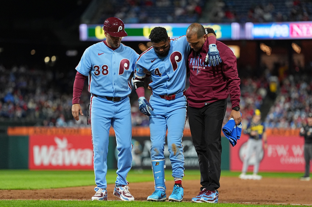 Philadelphia Phillies' Luis Arraez (4) is helped off the field after being injured during the sixth inning of a baseball game against the Milwaukee Brewers, Thursday, Sept. 24, 2026, in Philadelphia. (AP Photo/Matt Rourke)