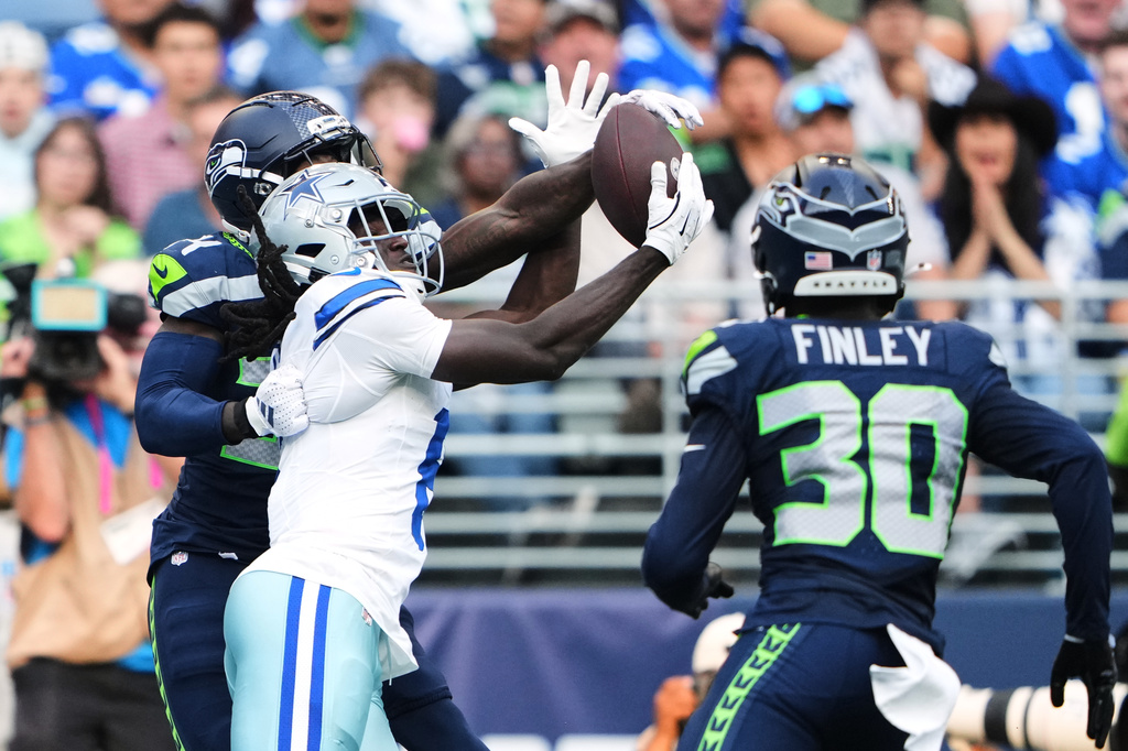 Dallas Cowboys wide receiver Camden Brown, center, catches a touchdown pass as Seattle Seahawks' Shemar Jean-Charles, left, and AJ Finley (30) defend in the first half of an NFL preseason football game, Saturday, Aug. 15, 2026, in Seattle. (AP Photo/Lindsey Wasson)