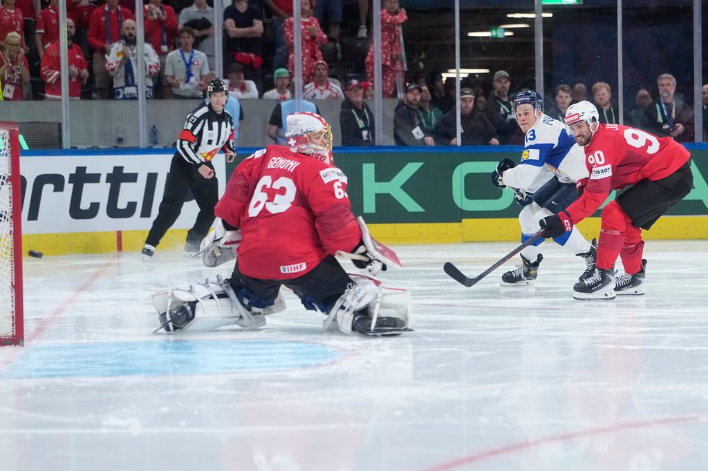 Finland's Jesse Puljujarvi (13) tries to score past Switzerland's goalkeeper Leonardo Genoni (63) during overtime in the 2026 IIHF Men's Ice Hockey World Championship final match between Switzerland and Finland, in Zurich, Switzerland, Sunday, May 31, 2026. (AP Photo/Darko Bandic)
