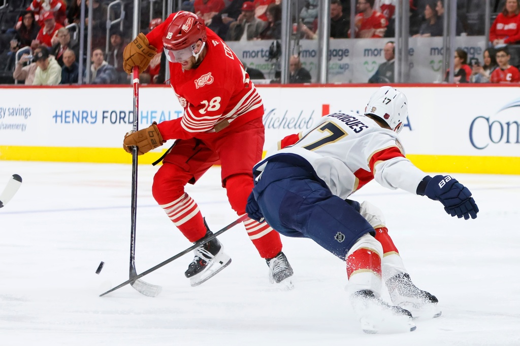 Detroit Red Wings center Andrew Copp (18) avoids Florida Panthers center Evan Rodrigues (17) to move the puck during the second period of an NHL hockey game Friday, March 6, 2026, in Detroit. (AP Photo/Duane Burleson)