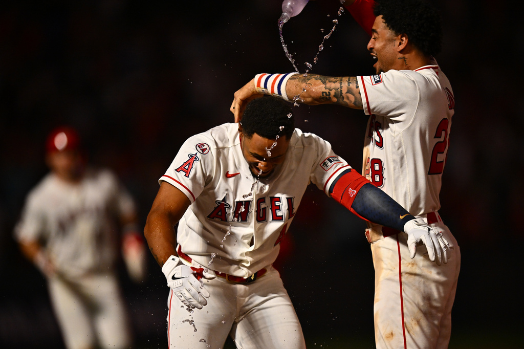 Los Angeles Angels' Christian Moore, center, is greeted by Jose Siri, right, after hitting a walk-off single during the 11th inning of a baseball game against the Minnesota Twins, Saturday, Sept. 19, 2026, in Anaheim, Calif. (AP Photo/William Liang)