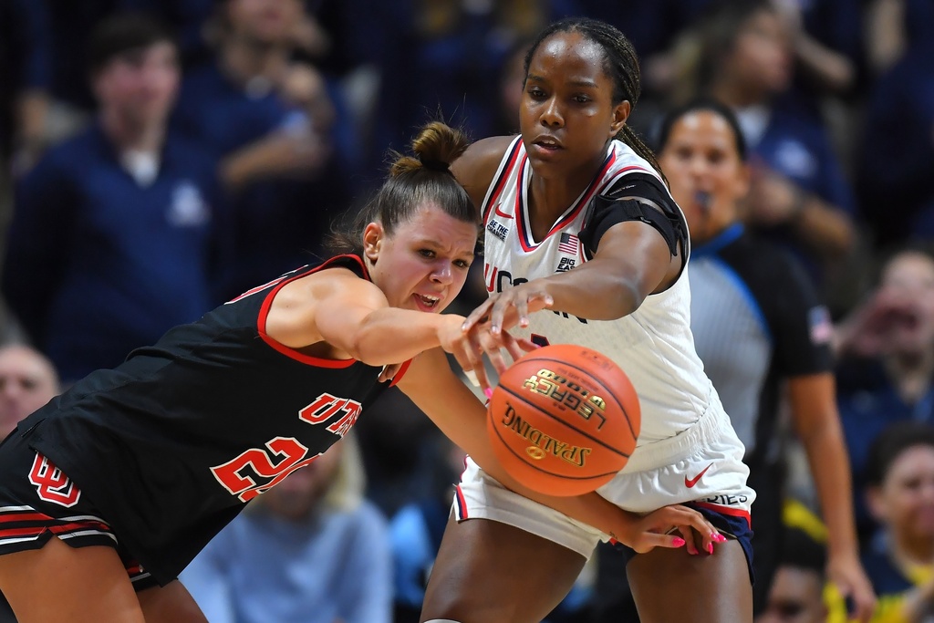 Utah forward Reese Ross, left, and UConn guard Blanca Quinonez, right, vie for the ball in the first half of an NCAA college basketball game, Sunday, Nov. 23, 2025, in Uncasville, Conn. (AP Photo/Steven Senne)