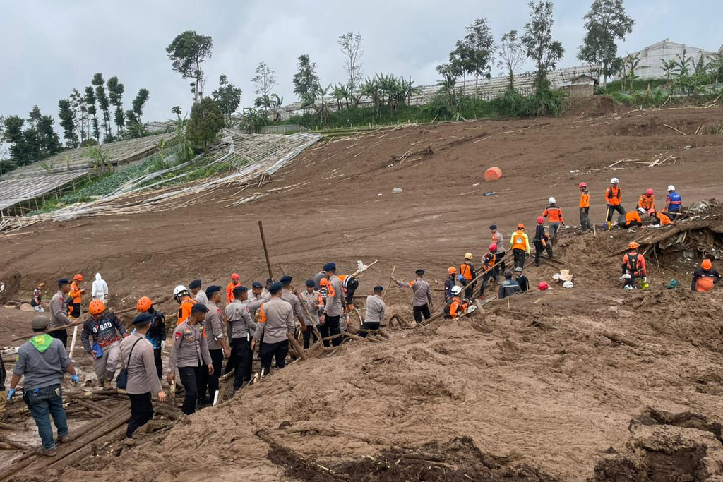 In this photo released by the Indonesian National Search and Rescue Agency (BASARNAS), rescuers search for victims in Pasir Langu village after a landslide, in West Bandung district of West Java province, Indonesia, Sunday, Jan. 25, 2026. (BASARNAS via AP)