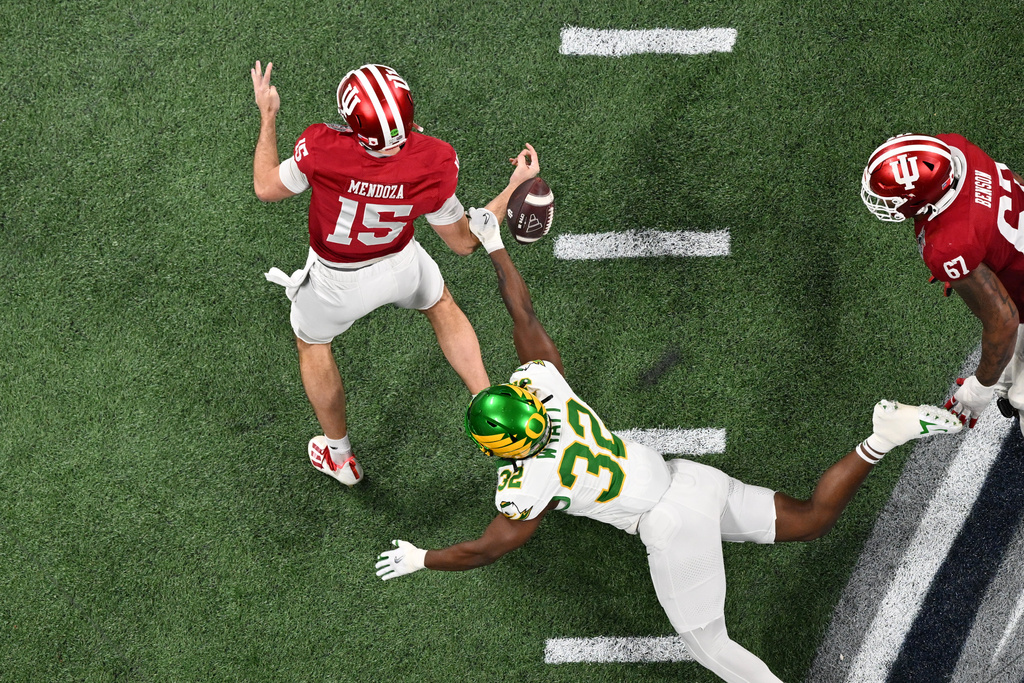 Oregon linebacker Nasir Wyatt (32) strips the ball from Indiana quarterback Fernando Mendoza (15) during the first half of the Peach Bowl NCAA college football playoff semifinal, Friday, Jan. 9, 2026, in Atlanta. (AP Photo/Danny Karnik)