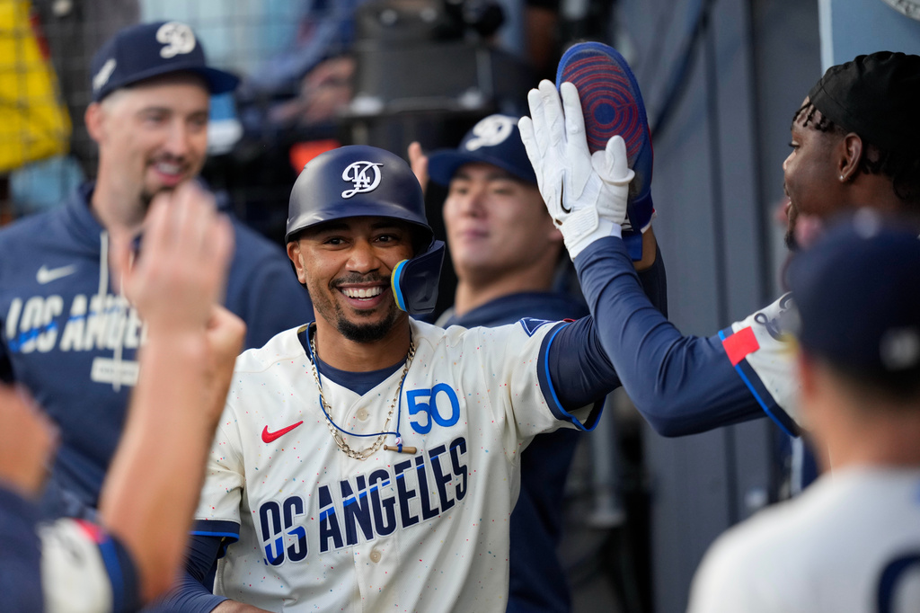 Los Angeles Dodgers' Mookie Betts is congratulated by teammates in the dugout after scoring on a double by Kyle Tucker during the first inning of a baseball game against the San Francisco Giants, Saturday, Sept. 19, 2026, in Los Angeles. (AP Photo/Mark J. Terrill)
