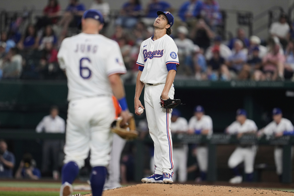 Texas Rangers starting pitcher Jacob deGrom reacts after giving up a walk as third baseman Josh Jung (6) approaches the mound in the sixth inning of a baseball game against the Houston Astros Saturday, Sept. 6, 2025, in Arlington, Texas. (AP Photo/Tony Gutierrez)