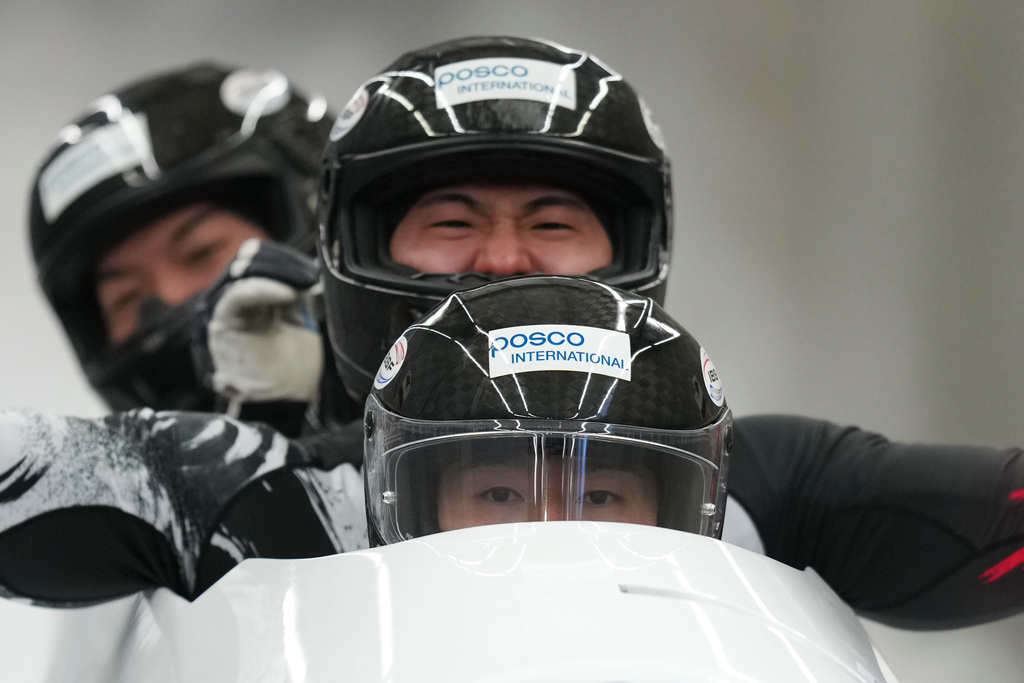 Kim Jinsu, Kim Sunwook, Kim Hyeonggeun and Lee Geonu, of South Korea, react as they finish their second run during the 4-man bobsleigh World Cup and Olympic test event in Cortina D'Ampezzo, Italy, Sunday, Nov. 23, 2025. (AP Photo/Andrew Medichini)