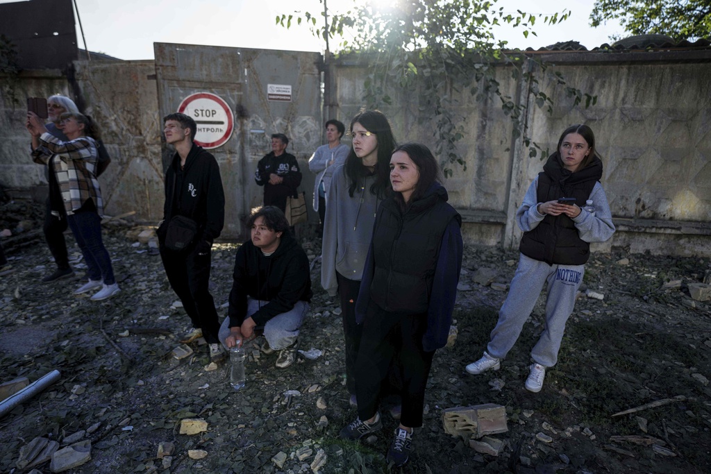People look on a residential building destroyed by a Russian strike in Kyiv, Ukraine, on Thursday, Aug. 28, 2025. (AP Photo/Evgeniy Maloletka)