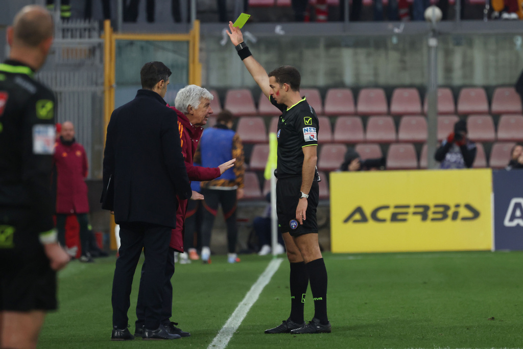 Referee Giovanni Ayroldi shows a yellow card to Roma's head coach Gian Piero Gasperini during the Italian Serie A soccer match between Cremonese and Roma in Cremona, Italy, Sunday, Nov. 23, 2025. (Alberto Mariani/LaPresse via AP)
