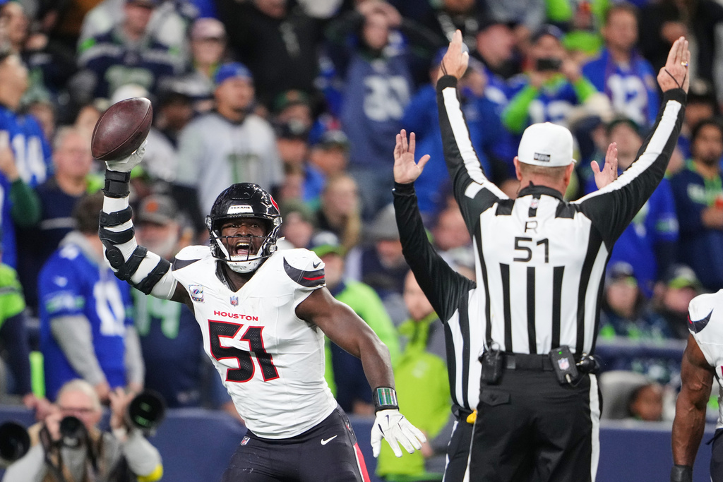 Houston Texans defensive end Will Anderson Jr. (51) celebrates after scoring a touchdown on a Seattle Seahawks fumble as referee Carl Cheffers (51) signals after the play in the second half of an NFL football game Monday, Oct. 20, 2025, in Seattle. (AP Photo/Lindsey Wasson)