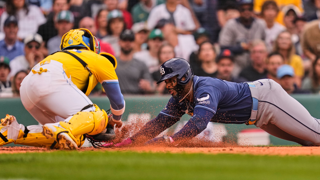 Tampa Bay Rays' Yandy Díaz, right, is tagged out by Boston Red Sox's Carlos Narváez, left, while trying to score on a double hit by Jonny DeLuca in the fourth inning of a baseball game, Saturday, July 18, 2026, in Boston. (AP Photo/Charles Krupa)