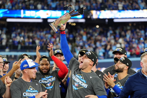 Toronto Blue Jays' George Springer holds the American League Championship Series trophy as the team celebrates after defeating the Seattle Mariners in Game 7 of the series in Toronto, Monday, Oct. 20, 2025. (Frank Gunn/The Canadian Press via AP) Toronto Blue Jays' George Springer holds the American League Championship Series trophy as the team celebrates after defeating the Seattle Mariners in Game 7 of the series in Toronto, Monday, Oct. 20, 2025. (Frank Gunn/The Canadian Press via AP)