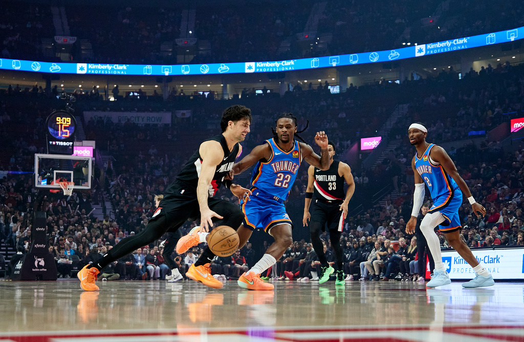 Portland Trail Blazers forward Deni Avdija, left, dribbles past Oklahoma City Thunder guard Cason Wallace during the first half of an NBA basketball game in Portland, Ore., Wednesday, Nov. 5, 2025. (AP Photo/Craig Mitchelldyer)