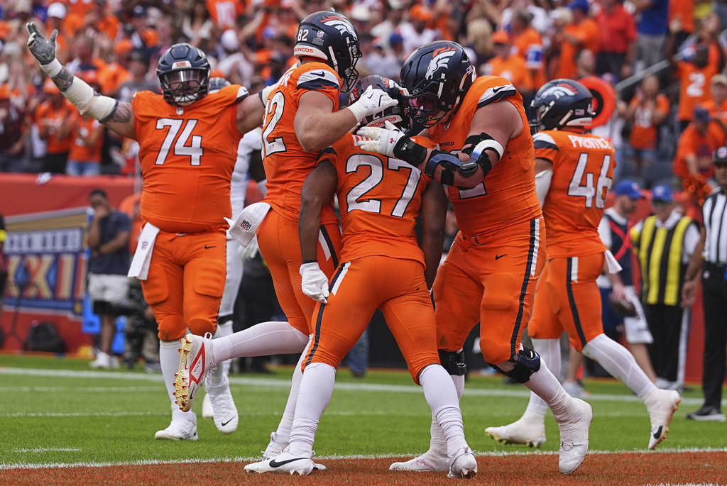 Denver Broncos running back J.K. Dobbins (27) is congratulated by teammates after a touchdown during the second half of an NFL football game against the Tennessee Titans, Sunday, Sept. 7, 2025, in Denver. (AP Photo/David Zalubowski)
