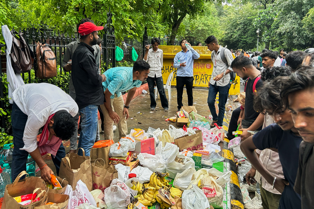 Protestors collect from a pile of assorted food items sent by supporters at the site where thousands have assembled to join a protest led by Cockroach Janta Party in New Delhi, India, Wednesday, July 22, 2026. (AP Photo/Piyush Nagpal)