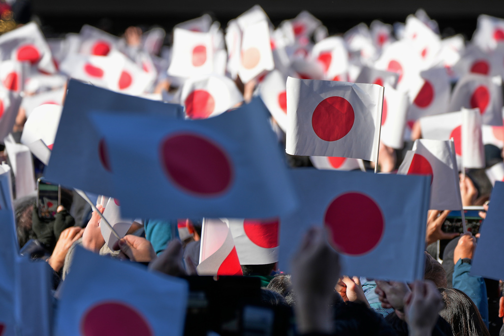 FILE - Well-wishers wave Japanese flags as Emperor Naruhito with his imperial families makes a public appearance at the balcony of Imperial Palace in Tokyo, Jan. 2, 2026. (AP Photo/Eugene Hoshiko, File)
