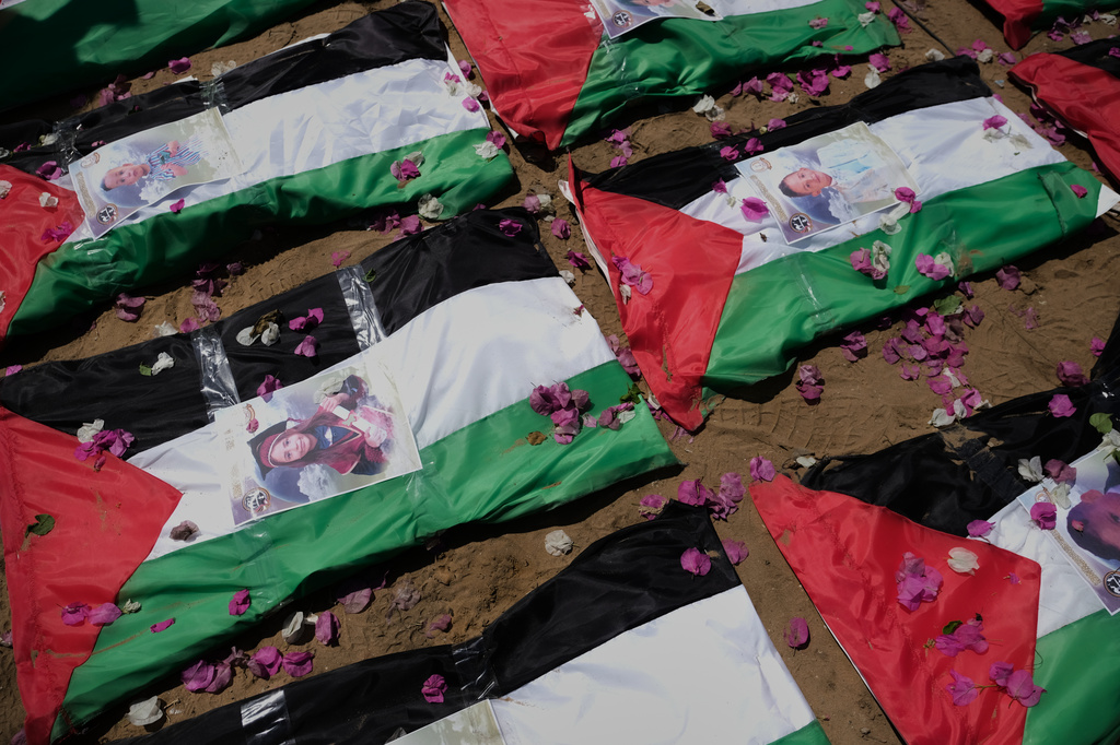 Bodies of members of the Hassayna and Abu Sharia families, killed in an Israeli strike in 2023 and recently recovered from the rubble, are draped in Palestinian flags during their funeral in Gaza City, Tuesday, Aug. 4, 2026. (AP Photo/Jehad Alshrafi)