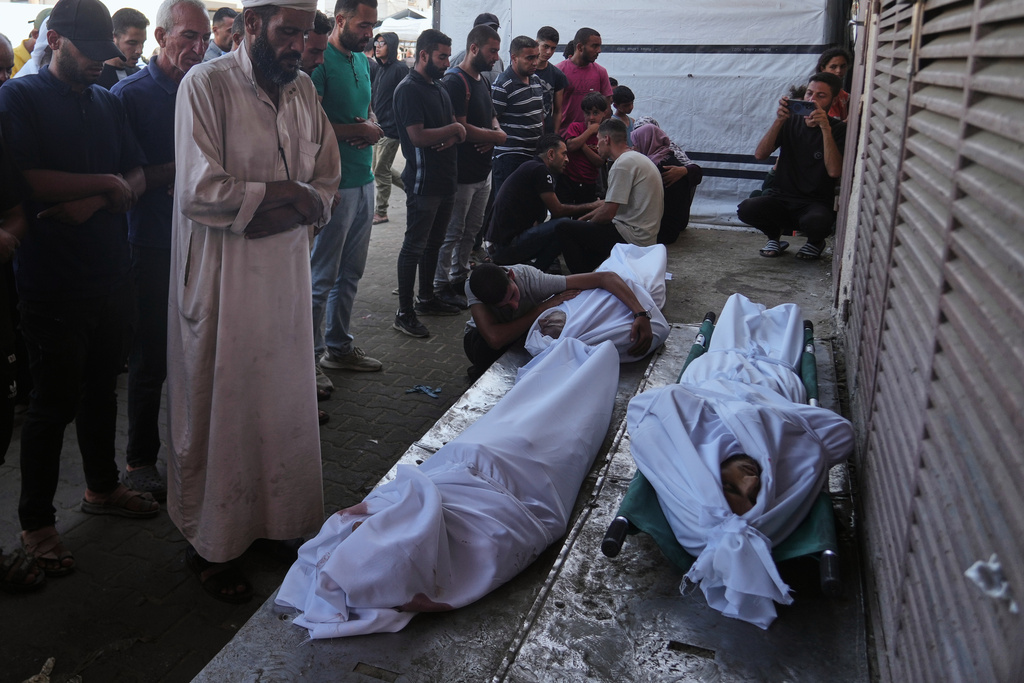 Mourners pray over the bodies of Palestinians killed by Israeli army shelling, during their funeral outside Al-Aqsa Hospital in Deir al-Balah, central Gaza Strip, Saturday, Oct. 4, 2025. (AP Photo/Abdel Kareem Hana)