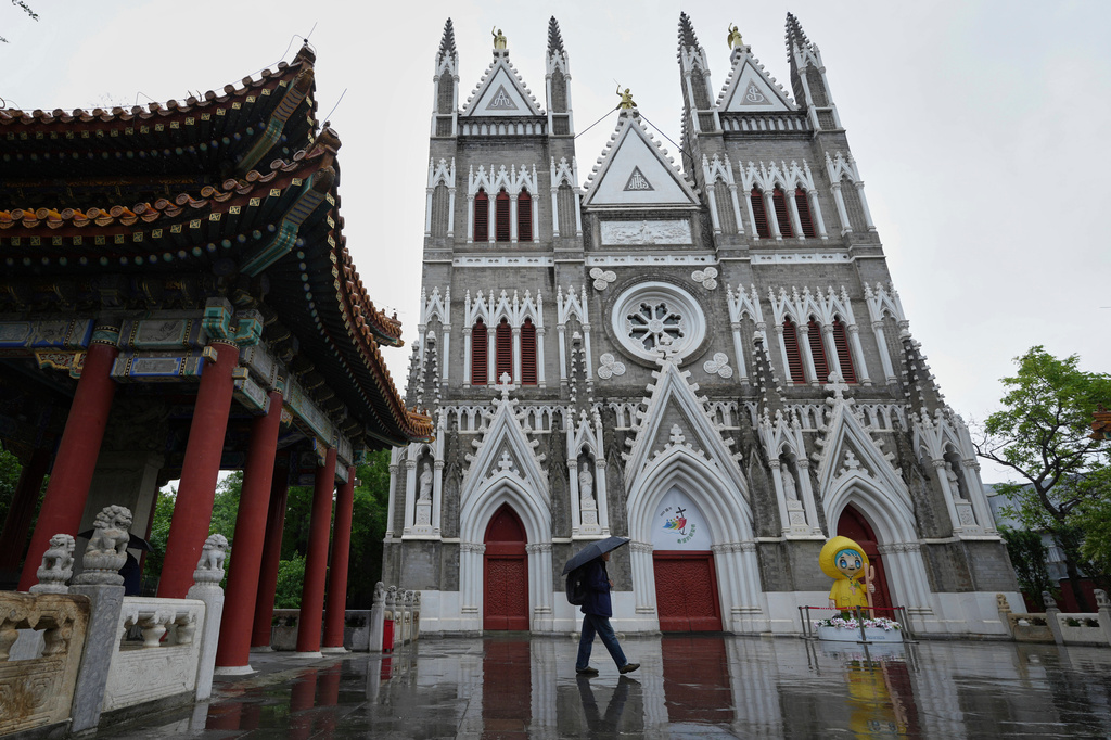 FILE - A man walks out from a pavilion near the Xishiku Catholic Church during a rainy day in Beijing, May 9, 2025. (AP Photo/Andy Wong, File)