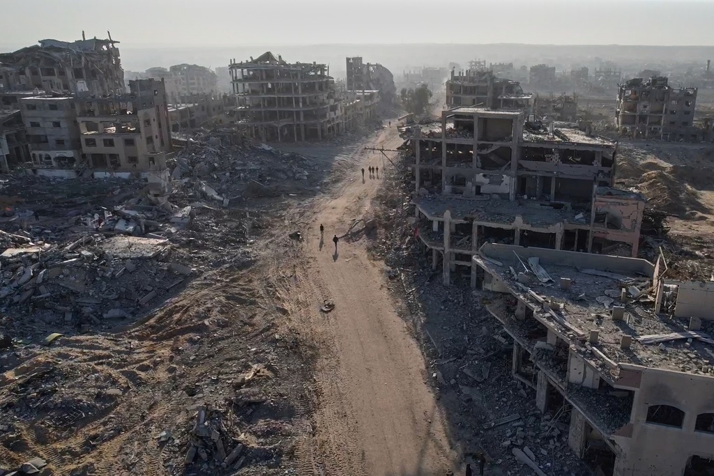 This frame grab from a drone video shot on Saturday, Oct. 11, 2025, shows Palestinians walking past destroyed buildings in Gaza City, in the northern Gaza Strip. (AP Photo)