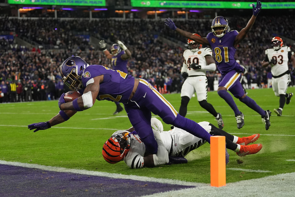 Baltimore Ravens running back Derrick Henry (22) scores a touchdown past Cincinnati Bengals linebacker Demetrius Knight Jr. (44) as Baltimore Ravens wide receiver Devontez Walker (81) celebrates during the first half of an NFL football game, Thursday, Nov. 27, 2025, in Baltimore. (AP Photo/Stephanie Scarbrough)