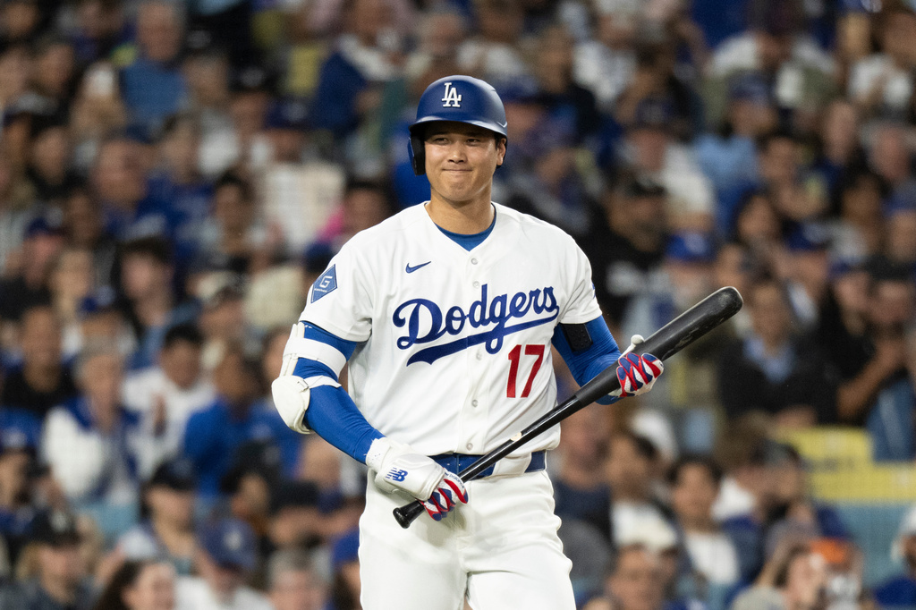 Los Angeles Dodgers' Shohei Ohtani smiles towards the Cleveland Guardians dugout during the first inning of a baseball game in Los Angeles, Tuesday, March 31, 2026. (AP Photo/Kyusung Gong)